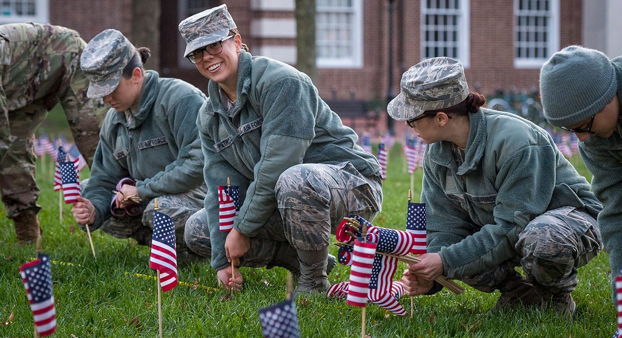 military service people planting American flags on the UD green