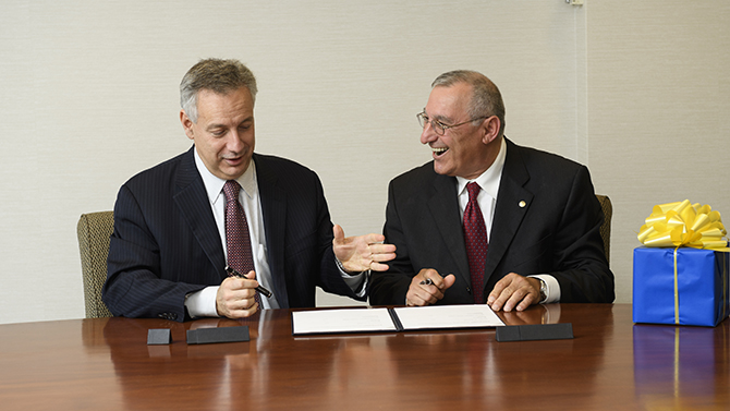 Dr. Dennis Assanis signs a treaty with Dr. Stefano Gialamas from the American Community School in Athens along with Dean Carol Vukelich, Bahira Trask, Ravi Ammigan and Dan (can't find last name).