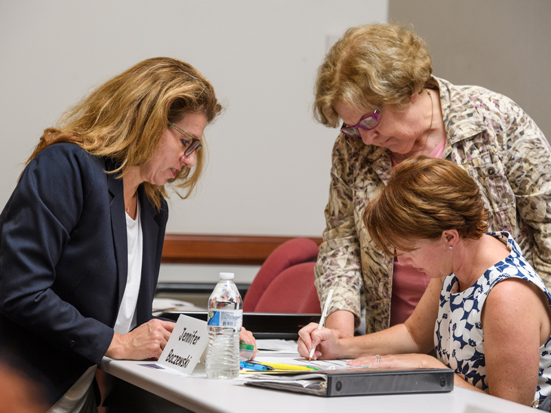 UD alumna and economic education leader Mary Suiter (center) works with a current UD MAEEE student during her recent presentation at the University.
