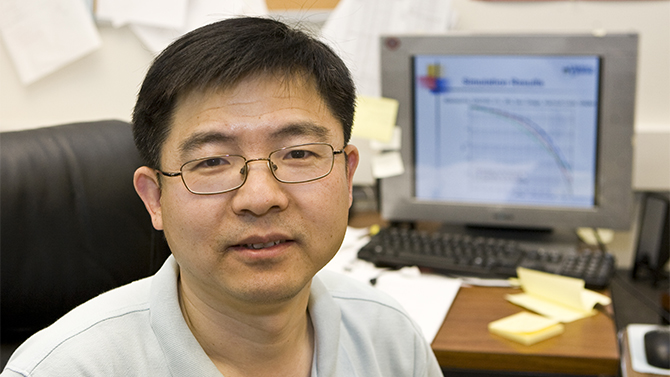 Xiang-Gen Xia  from Electrical and Computer Engineering in his office and in his lab with students.