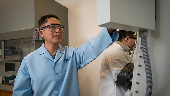 Bingqing Wei, Mechanical Engineering and his doctoral students Zeyuan Cao and TaoLi Gu (spiky hair with bangs) work with batteries in the lab in Spencer Lab.