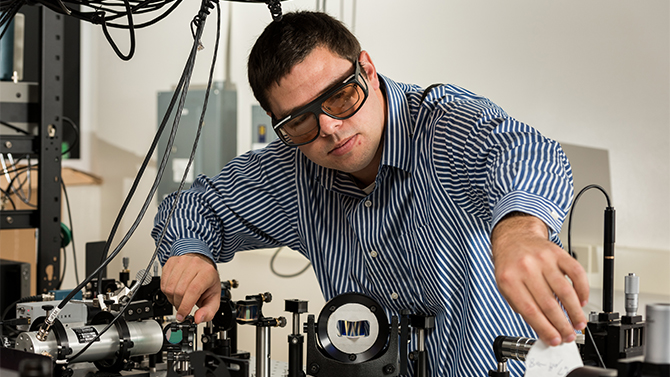 Associate Professor Joseph Feser, mechanical engineering, working in his Spencer Hall lab with an optical workbench. Feser's work is in "the development of new thin-film thermoelectric device architectures, and experimental characterization of heat transfer on ultrafast timescales/ultra-small length scales."