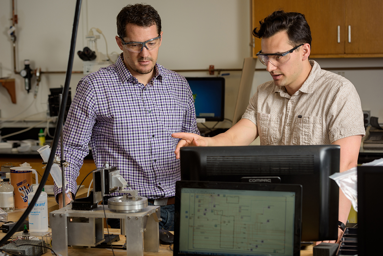 ENGR-Moore-Burris-Tribology_Lab-041217 Axel Moore (tan shirt), a second year Biomedical Engineering Graduate Student with research interests are in the area of soft tissue tribology. Photographed with David Burris, associate professor of Mechanical Engineering, in the Tribology Laboratory in Spencer Lab for a UDaily article about Moore receiving an international fellowship. - (Evan Krape / University of Delaware)