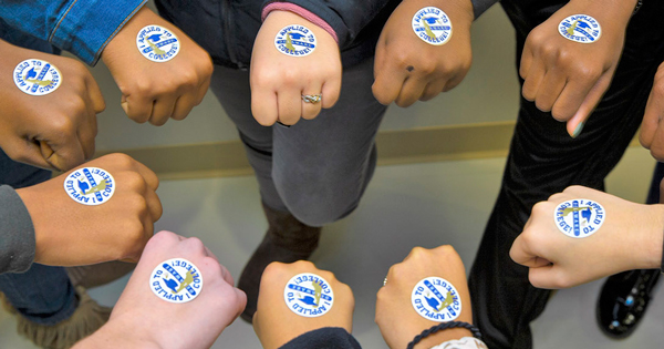 Delaware high school seniors show off their “I Applied to College” stickers in honor of College Application Month.