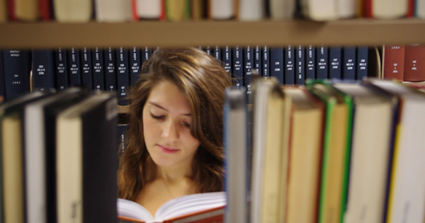 UD Library looking at books on shelves