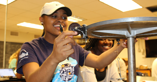 Exercise Science Junior Adassa Phillips conducts an experiment with physics lab partner Christabelle Ayensu-Asiedu. 
