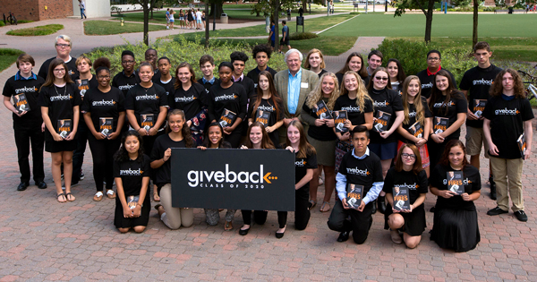 Bob Carr, founder and CEO of Give Something Back, is surrounded by students who will have the opportunity to attend UD through the Give Back mentoring and scholarship program.
