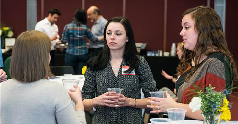 Laura Johnson (left) and Sierra Patterson (right) speak with an employer at the 2018 Geo Job Fair.