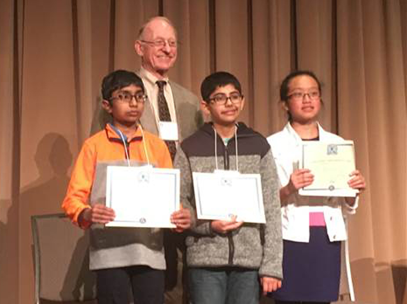 The top finishers in the 30th annual Delaware State Geography Bee are, left to right, Jeremiah Rayban, Agni Miraji-Khot and Anna Nguyen. Standing behind them is Dr. Peter Rees, professor emeritus in the University of Delaware Geography Department.