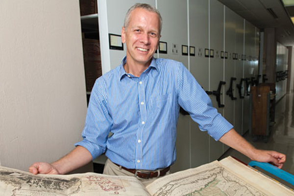 Martin Brückner examines an atlas in UD Special Collections in 2013, when an exhibit based on his research on maps opened at Winterthur Museum.
