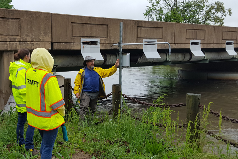 CEMA’s David Huntley explains the low-cost flood sensing equipment to transportation and emergency management officials from state and federal agencies.