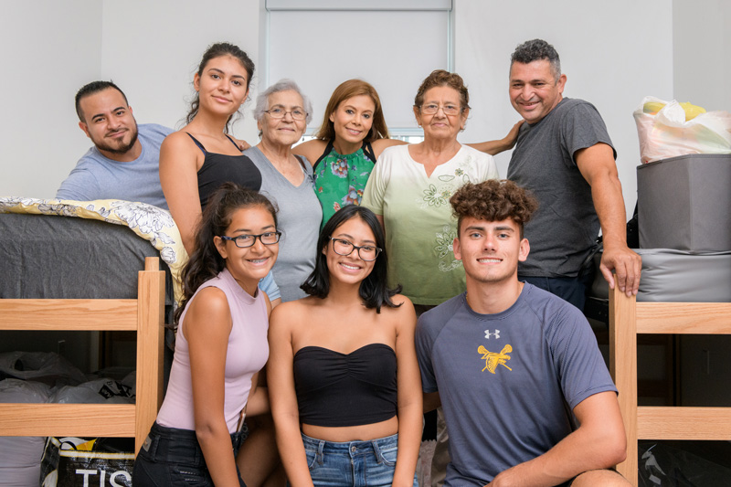 Bianca Asencio (bottom center), a first-year student in the College of Health Sciences, had plenty of help from her family while moving into her residence hall on Saturday.