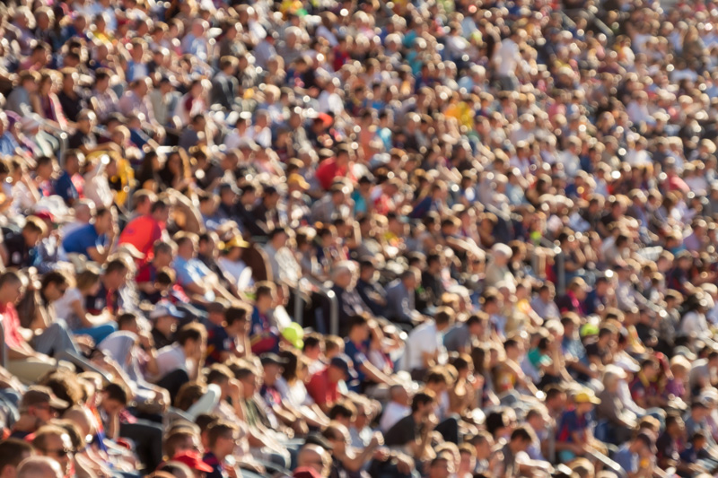 Blurred out people attending an event at an outdoor stadium