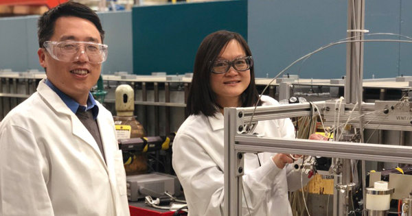 Yun Liu (left) and Wei-Shan Chiang adjust a syringe pump used to control gas pressure.
