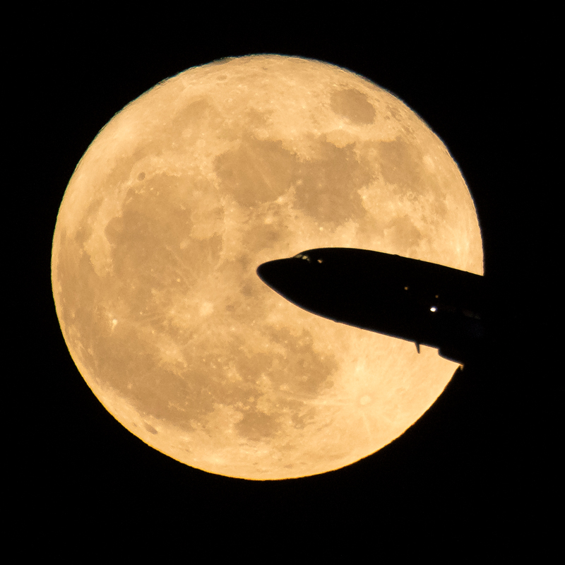 Supermoon Airplane takes off with supermoon in the background