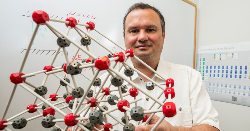 Anderson Janotti is pictured with a model that represents the structure of an advanced electronic material.