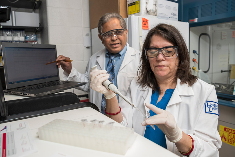 Sam Biswas and Esther Biswas-Fiss do research on HPV-DNA binding protein testing in Flourometer with graduate student Meera Patel.