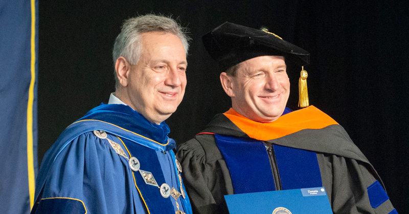 University of Delaware President Dennis Assanis (left) presents Engineering Professor Dennis Prather with the 2018 Outstanding Doctoral Graduate Advising and Mentoring Award during UD’s doctoral hooding ceremony on Friday, May 25.
