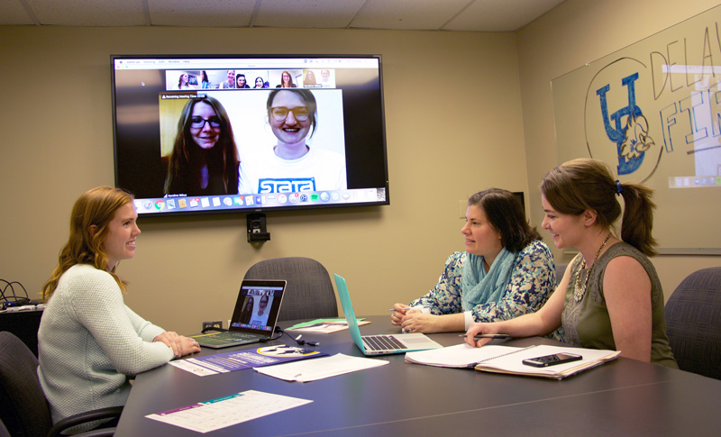 Seated left to right: Kathleen McCallops, Cory Gilden and Ginnie Sawyer Morris, doctoral students in Human Development and Family Sciences, connect virtually with colleagues in Greece and Germany to develop a conference that fosters collaborative research. 