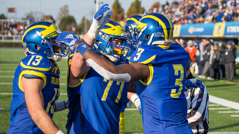 Three UD players celebrate