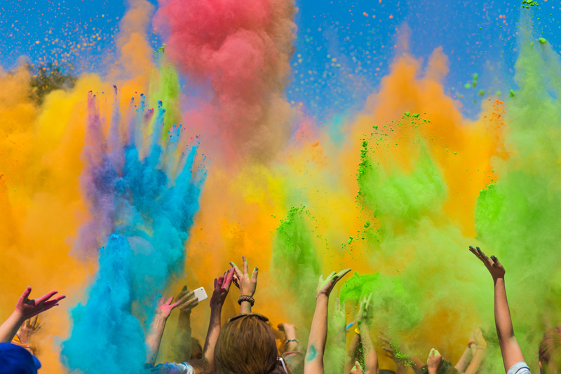 crowd of people throwing colored paint on Holi festival