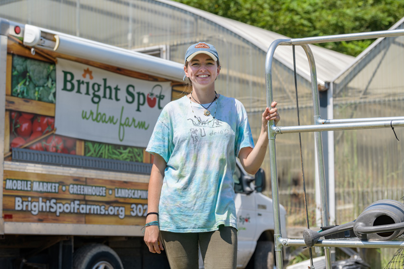 CAS-PSYCH-Groman-Bright_Spot_Farms-080919 Undergraduate Research Scholar Emma Groman is a student of Psychology and Sociology and spent her 2019 summer working with the Bright Spot farm program. A community garden created by West End Neighborhood House in 2011, Bright Spot Farms both generates produce for local Wilmington communities while also providing educational opportunities for City of Wilmington youth.