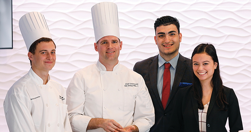 Hospitality business management students pose with Executive Chef John Deflieze at Vita Nova.