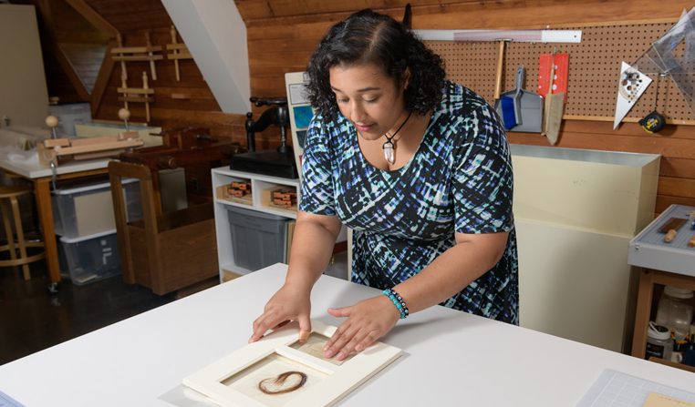 Layla Huff (blue, white, black patterned dress) is an undergraduate student at Morgan State University who has been studying art conservation at Winterthur for an internship in the summer of 2019. Working with mentor Melissa Tedone, Huff has been preparing a lock of hair for exhibition in England. The hair comes from Elizabeth “Lizzie” Siddall, an English artist, poet, and artists' model. Until her husband, painter Dante Gabriel Rossetti, made her his exclusive model, Lizzie frequently modeled for drawing and paintings by the Pre-Raphaelite Brotherhood. The lock of hair comes from the Mark Samuels Lasner Collection (MSL Coll 6690) and was a 