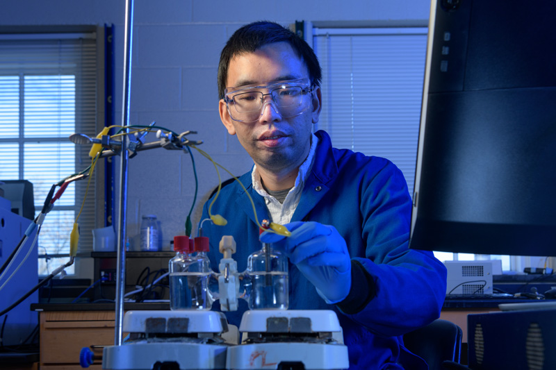 Feng Jiao, associate professor of Chemical and Biomolecular Engineering, in his Colburn Laboratory lab with a copper-titanium catalyst he is researching to cleanly split water into hydrogen gas for use in industrial processes. - (Evan Krape / University of Delaware)