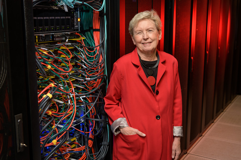 Jane Caviness, director of the University of Delaware's Academic Computing Services in the 1980s and who later oversaw the implementation of the NSF Network (NSFNET) backbone, photographed with an eponymously named community computing cluster in IT's Chapel Street computing center. The Caviness Community Cluster is UD's third High Performance Computing (HPC) cluster and came online in October of 2018 for UD research use. - (Evan Krape / University of Delaware)