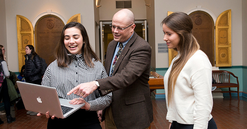 MIS professor Mark Serva and student mentees Emma Lavelle and Julia Forster in Memorial Hall on December 6, 2018.
