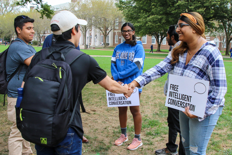 "Let's Talk" president Sansskruty Rayavarapu (right) greets students on the green as part of Free Intelligent Conversation.