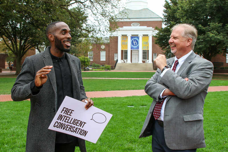 Free Intelligent Conversation founder and executive director, Kyle Emile (left) shares a funny story with College of Arts & Sciences dean John Pelesko during an October event on The Green.