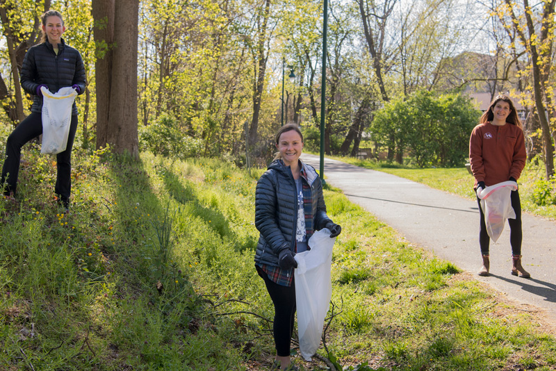 OCM - UDaily - Earth Day - 2020 Clare Bondi ’20 (rust sweater), Jennifer Yarin ’20 (blue puffy jacket, blonde hair) and Lily Wolf ’20 (black puffy jacket, ponytail) are part of group called the Outing Club that does outdoor activities such as camping and hiking. Today they are doing a clean-up as part of Earth Day.