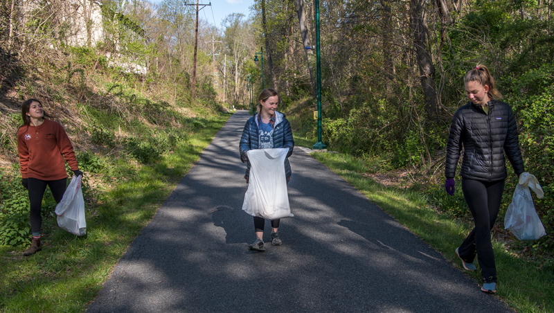 Clare Bondi ’20 (rust sweater), Jennifer Yarin ’20 (blue puffy jacket, blonde hair) and Lily Wolf ’20 (black puffy jacket, ponytail) are part of group called the Outing Club that does outdoor activities such as camping and hiking.  Today they are doing a clean-up as part of Earth Day. 