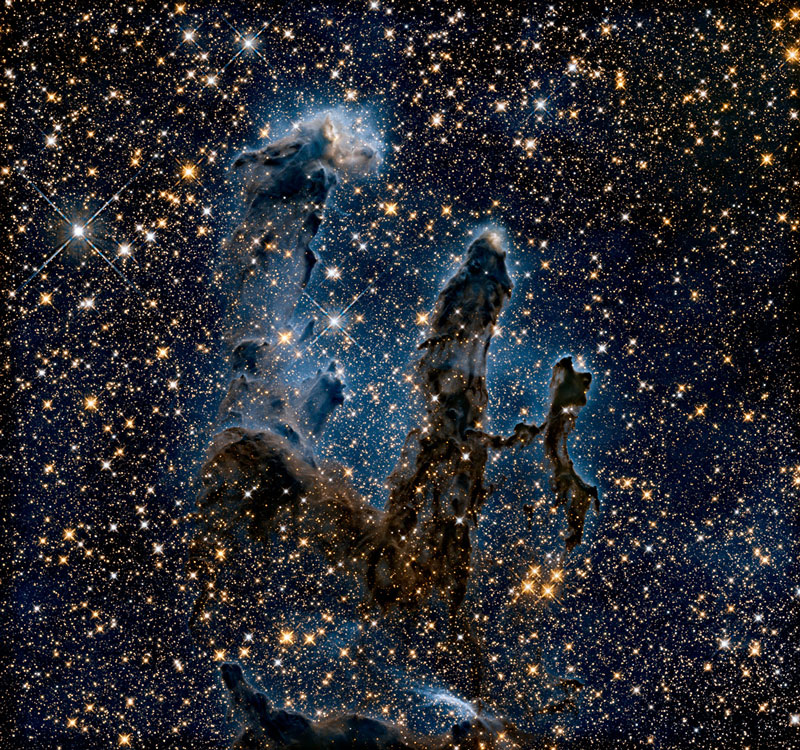 New view of the Pillars of Creation — infrared The NASA/ESA Hubble Space Telescope has revisited one of its most iconic and popular images: the Eagle Nebula’s Pillars of Creation. This image shows the pillars as seen in infrared light, allowing it to pierce through obscuring dust and gas and unveil a more unfamiliar — but just as amazing — view of the pillars. In this ethereal view the entire frame is peppered with bright stars and baby stars are revealed being formed within the pillars themselves. The ghostly outlines of the pillars seem much more delicate, and are silhouetted against an eerie blue haze. Hubble also captured the pillars in visible light.