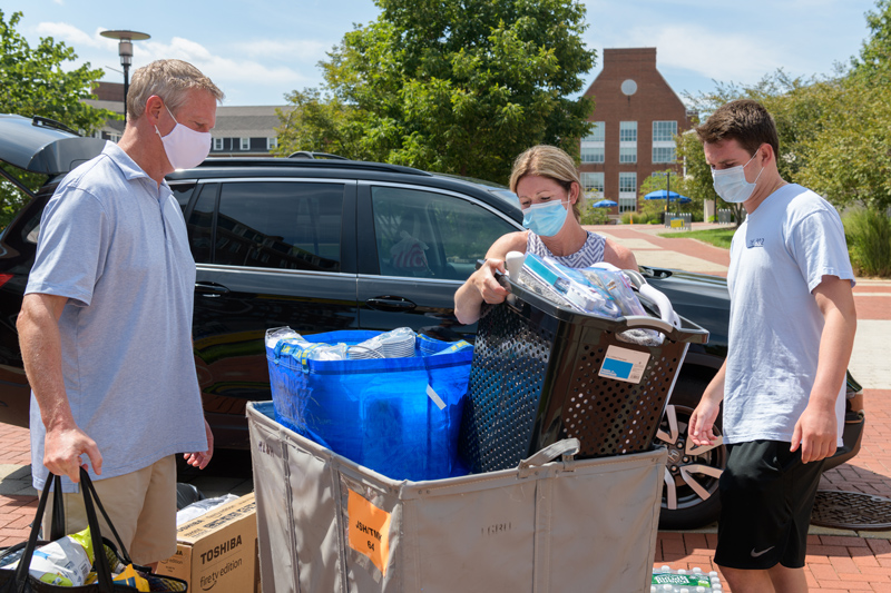 RLH-Move_In-EK-082620 UD's first day of a new, multi-day staggered move-in designed to accommodate the social distancing and health considerations required to safely bring students back to school amidst the COVID-19 pandemic. Only about 1,300 students will be returning to living in on-campus housing and their move-in has been spread across 5 days.
Pictured: First year student Jack Wootten (right) gets help from his parents (and Double Dels) Maisy (middle) and Gary (left)