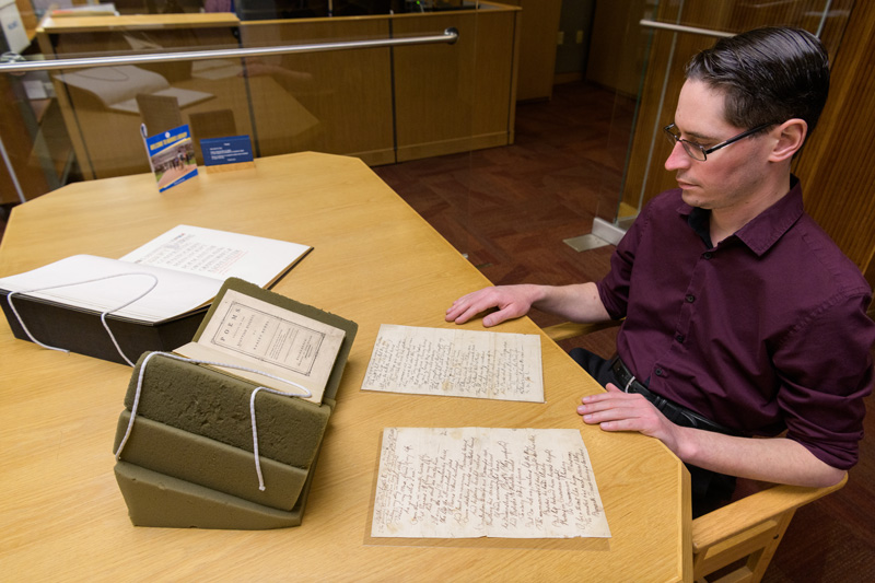 Alex Johnston, associate librarian and coordinator for books and printed materials, shows several works the University of Delaware has by the renowned Scottish poet Robert Burns which are held by Special Collections in the Morris Library. The collection includes a first edition of "Poems, chiefly in the Scottish dialect" (PR4300 1786 .K54); two original, handwritten poems published posthumously (MSS 099, F592); and a bound collection of some correspondence and poems by Burns (MSS 099, F592).