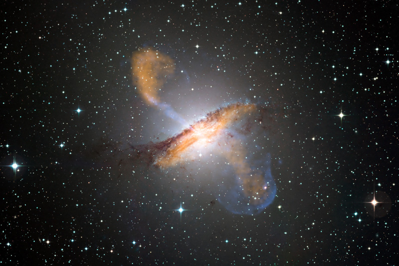 Centaurus A Colour composite image of Centaurus A, revealing the lobes and jets emanating from the active galaxy’s central black hole. This is a composite of images obtained with three instruments, operating at very different wavelengths. The 870-micron submillimetre data, from LABOCA on APEX, are shown in orange. X-ray data from the Chandra X-ray Observatory are shown in blue. Visible light data from the Wide Field Imager (WFI) on the MPG/ESO 2.2 m telescope located at La Silla, Chile, show the stars and the galaxy’s characteristic dust lane in close to "true colour". #L