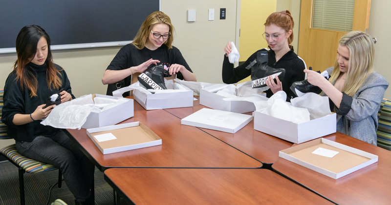 CAS-FASH-Ruthie_Davis_Interns_Gift-022620 Students in Fashion and Apparel Studies who've been interning with high-end shoe designer Ruthie Davis pairs of shoes from Ruthie as a "thank you." The shoes were designed as part of a promotional tie-in with the live action "Mulan" film and the students will have an opportunity to wear them on the red carpet when they attend an opening of the film in Los Angeles.