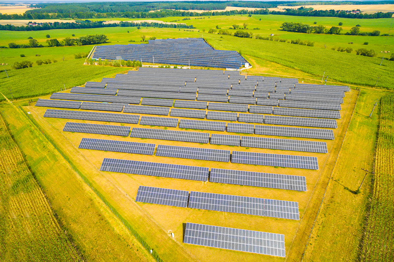 Aerial view to solar power plant in corn fields. Industrial background on renewable resources theme.