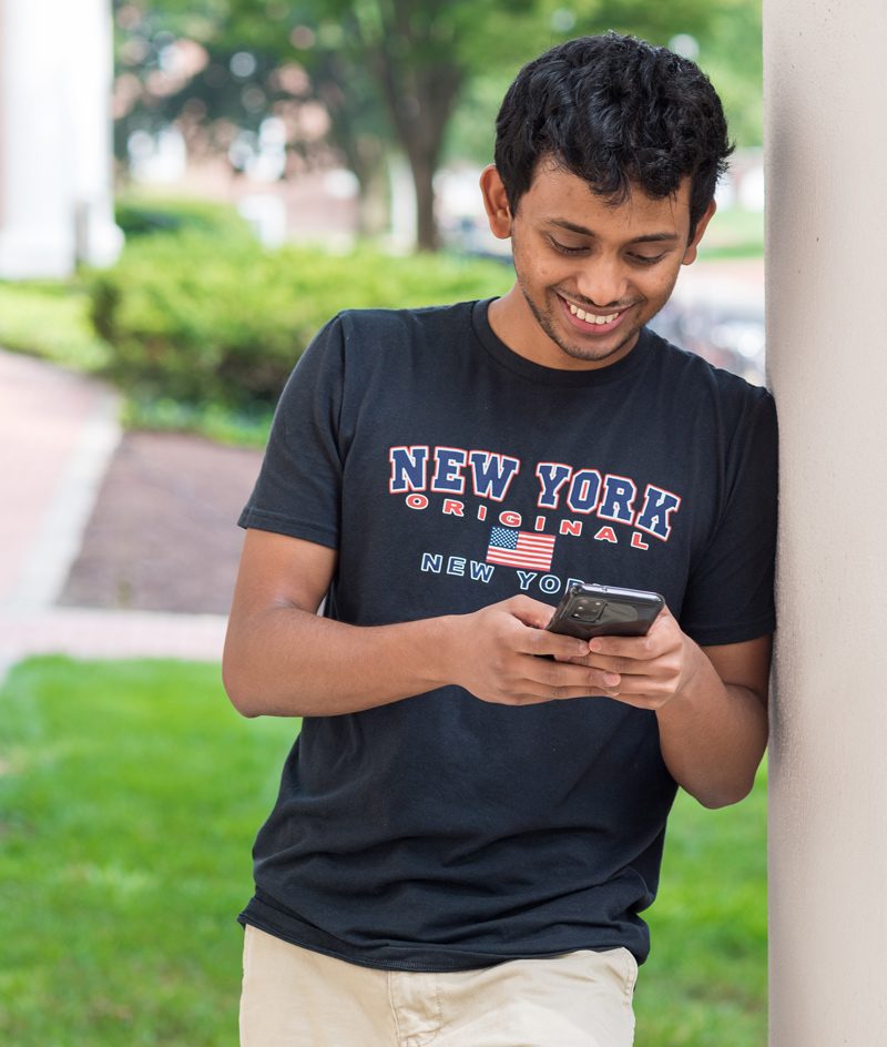Students & faculty welcome back a new Fall 2021 semester as they hurry to classes for the start of classes. Mevil Crasta, a Master's student from Baltimore, MD takes a break between classes on the steps of Gore Hall. 