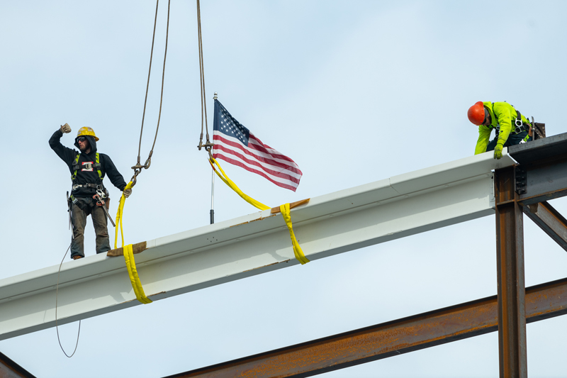 The final beam being raised for the topping out of the FinTech building. Signed by representatives of the University of Delaware, Bancroft Construction, and Discover Financial Services, the final beam represents a milestone in the construction of the building which is due to be finished in November of 2021.