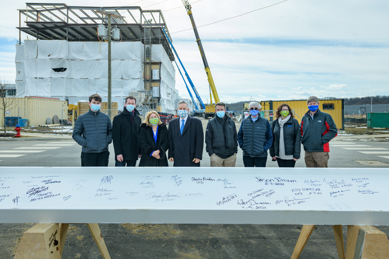 STAR-FinTech_Building_Construction-020621 Beam signing ceremony for the ceremonial last beam to “top out” the FinTech building on UD’s STAR campus. Built by a partnership between UD, the Delaware Technology Park (DTP), and Discover Bank, the building will allow the partners to tap into the world of financial services technology (fintech).
Pictured (from left): John Weber, Business and Economics class of ’23; Bruce Weber, Dean of the Alfred Lerner College of Business and Economics; Eleni Assanis; Dennis Assanis, President of the University of Delaware; Matt Parks, Vice President Investments, CRA, and Retail Banking with Discover Financial Services and ’02 University of Delaware MBA Alumni; Mike Bowman, Associate Director of the Office of Economic Innovation and Partnerships; Beth Brand, Vice President and University Secretary; Charlie Riordan, Vice President of Research, Scholarship, and Innovation and Professor of Chemistry and Biochemistry