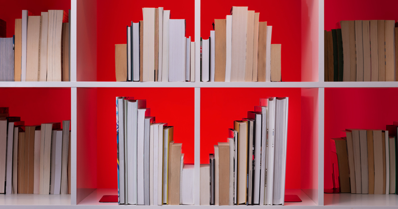 Books on a bookshelf arranged in the shape of a heart. Photographed for a UDaily story on romantic literature.