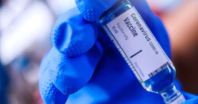 Image of Hand holds Coronavirus Covid-19 Vaccine glass bottle.