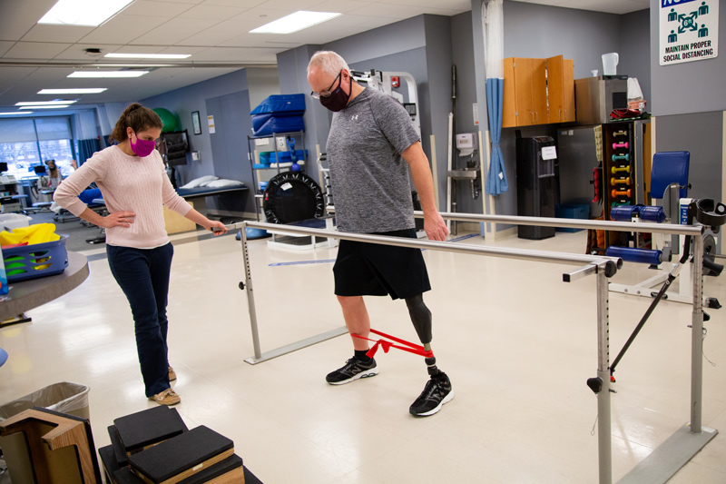 CHS-PT-Amputee-Glenn-Runyon-021121 Glenn Runyon works with Sarah Smith in the UD Physical Therapy Clinic. Glenn underwent osseointegration, which involves a metal rod being inserted into the a bone in place of wearing a socket. This is a fairly rare procedure - less than 200 of these type of surgeries in the U.S. Runyon is a history teacher and football coach for Concord High School.
Glenn also works with John Horne of Independence Prosthetics & Orthotics