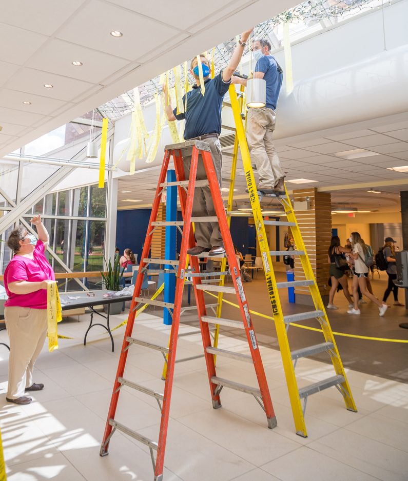 Mike Chalmers and Jeff Chase from the Office of Communications and Marketing work with Lisa Gensel of University Archives to select and hang hundreds of ribbons in Perkins Student Center as part of the University's commemoration of the 20th anniversary of the 9/11 terrorist attacks in 2001. The ribbons, each with handwritten messages from members of the University students, faculty, staff and the surrounding communities, were flown by the thousands on the south side of Memorial Hall in a ribbon garden created in the weeks after the attacks.