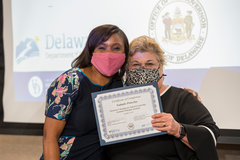Nathalie Princilus, now supervisor of unique programs in Christina School District, receives her certification of completion from Jacquelyn Wilson, director of the Delaware Academy of School Leadership, after graduating from UD’s Governor’s Institute of School Leadership.
