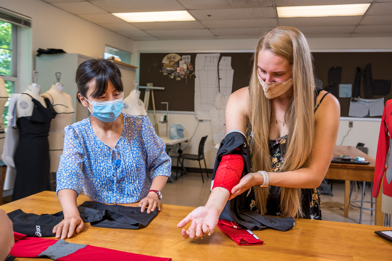 Jenna Tomasch (right), a sophomore fashion design and product innovation major, and visiting scholar Jie Diao examine the sleeve of a volleyball uniform. “We want to make sure that garments are comfortable to wear so that way they're not restricting movement,” Tomasch said. “If you're not confident and comfortable in your uniform, you're not going to play well, so we really want to make sure that things fit the way athletes want them to so that they can play to the best of their ability.”